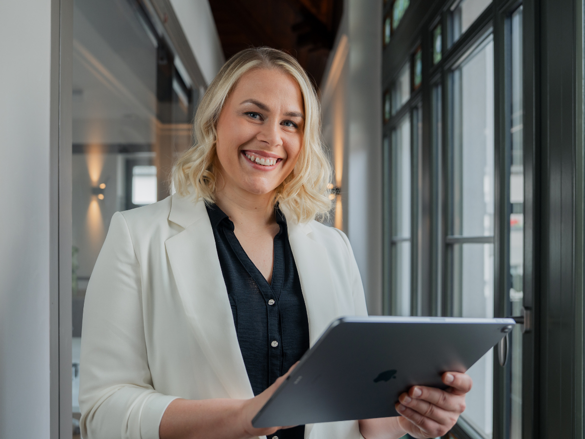 Christiane Reppe arbeitet konzentriert mit einem Tablet im hellen Büroflur