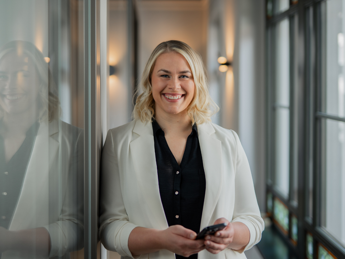 Christiane Reppe, Geschäftsführerin bei REPPE Immobilienbewertung, hält ein Smartphone und blickt freundlich in die Kamera