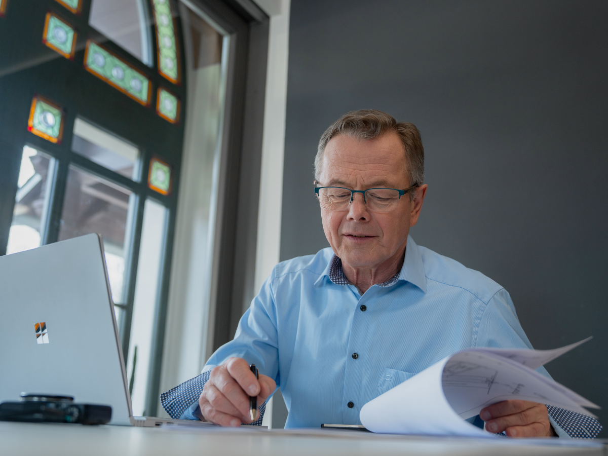 Hans-Jürgen Reppe, Immobilienbewerter bei REPPE, vertieft in die Prüfung von Bauplänen am Schreibtisch