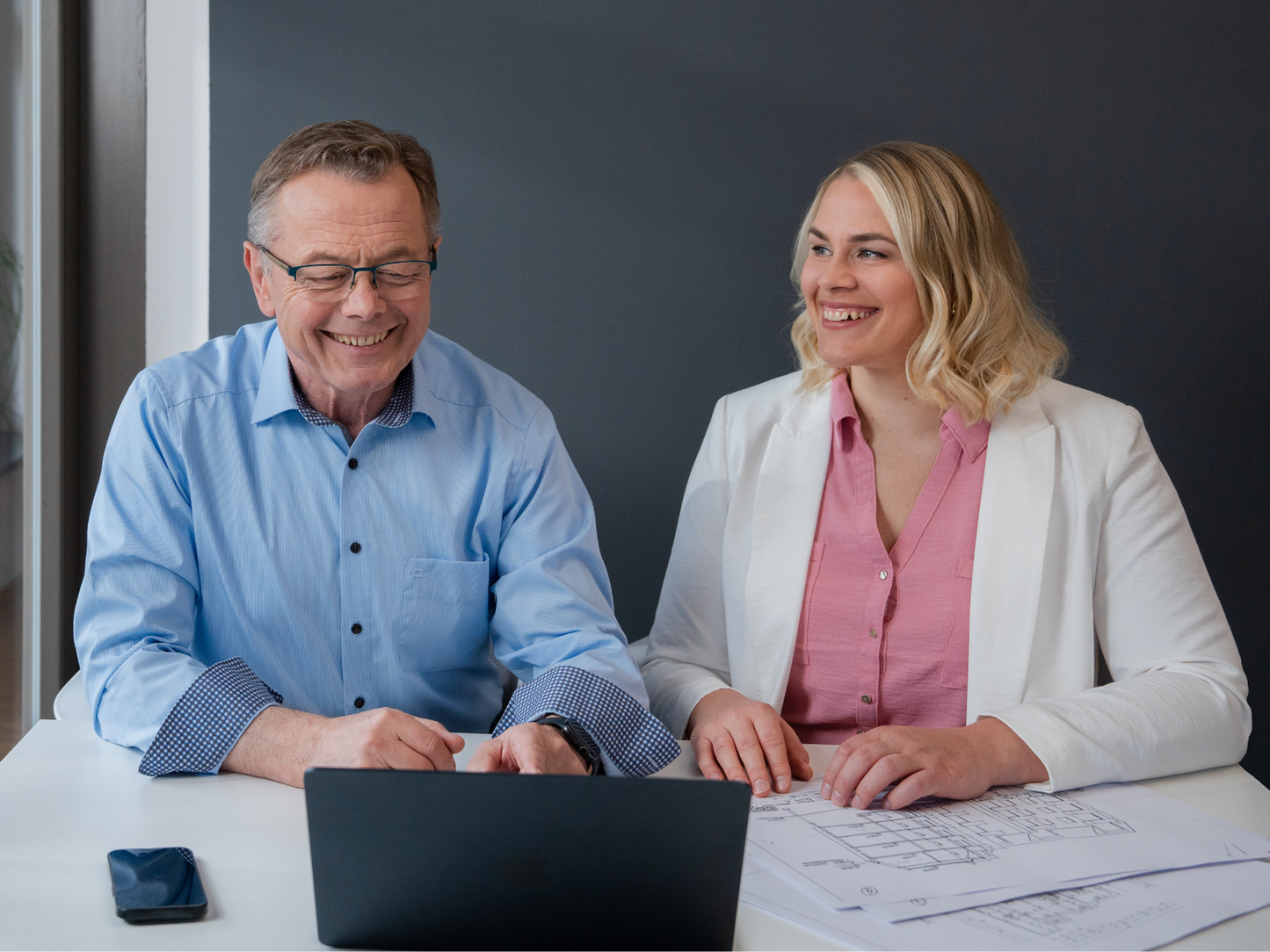 Hans-Jürgen Reppe und Christiane Reppe arbeiten gemeinsam an einem Laptop und studieren Grundrisspläne.