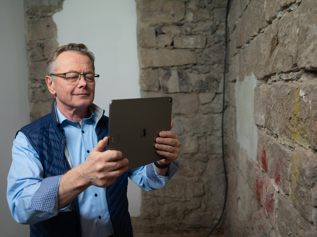 Immobilienbewertung durch einen unserer erfahrenen Sachverständigen Hans-Jürgen Reppe vor einer Kellerwand.