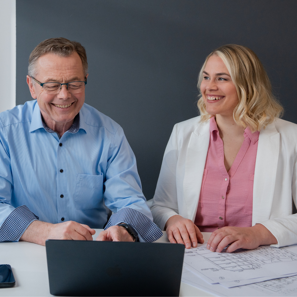 Hans-Jürgen Reppe und Christiane Reppe arbeiten gemeinsam an einem Laptop und studieren Grundrisspläne.